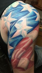 Tattoo of the American flag covering a person's upper arm. Blue stars, red and white stripes.