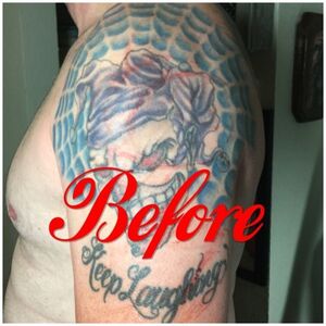 Tattooed arm with a colorful skull design within a blue web and