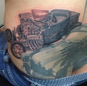 Tattoo of a hot rod car with a large engine, on a personâ€™s torso, part of a larger design.