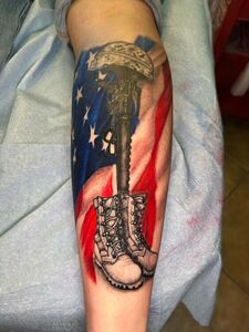 American flag background with a fallen soldier memorial tattoo.