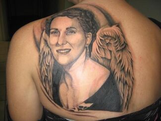 Tattoo of a person with angel wings on a back. Black and white portrait with a smiling face.