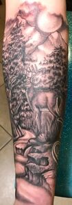 Black and gray tattoo of a deer in a forest landscape with mountains and a moon in the background.