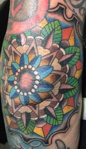 Colorful geometric mandala tattoo on skin.
