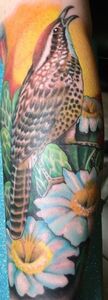 A detailed bird tattoo in a garden with daisies.