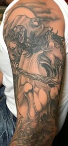 Tattoo of a figure holding a branch with a skull-like face and a full moon in the background.