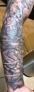 Tattoo of a detailed, dark gray, and white illustrative design covering an arm.