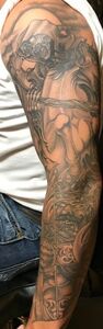 Tattoo sleeve depicting a detailed, grayscale, fantastical scene on an arm.