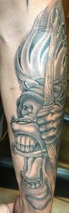 Tattoo of a person holding a knife with a screaming face. Grayscale.