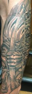 A detailed grayscale tattoo of a warrior holding a sword on a person's arm.