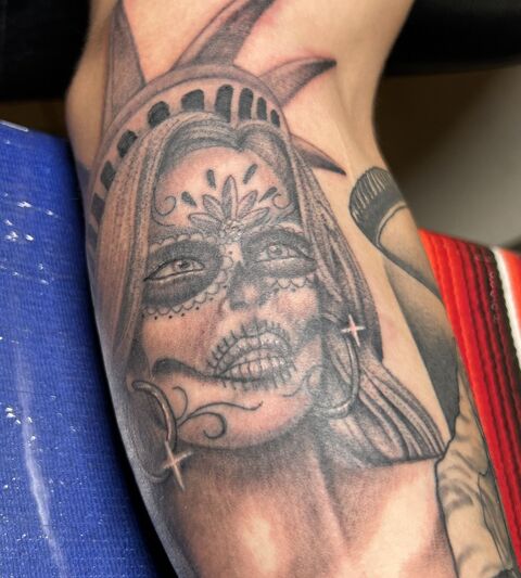 Black and grey Catrina portrait tattoo on a forearm