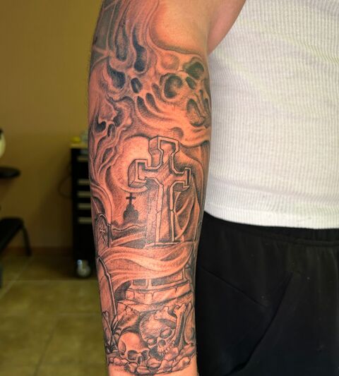 Black and grey forearm sleeve with a cross and clouds