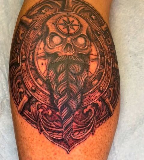Viking skull compass tattoo on a calf