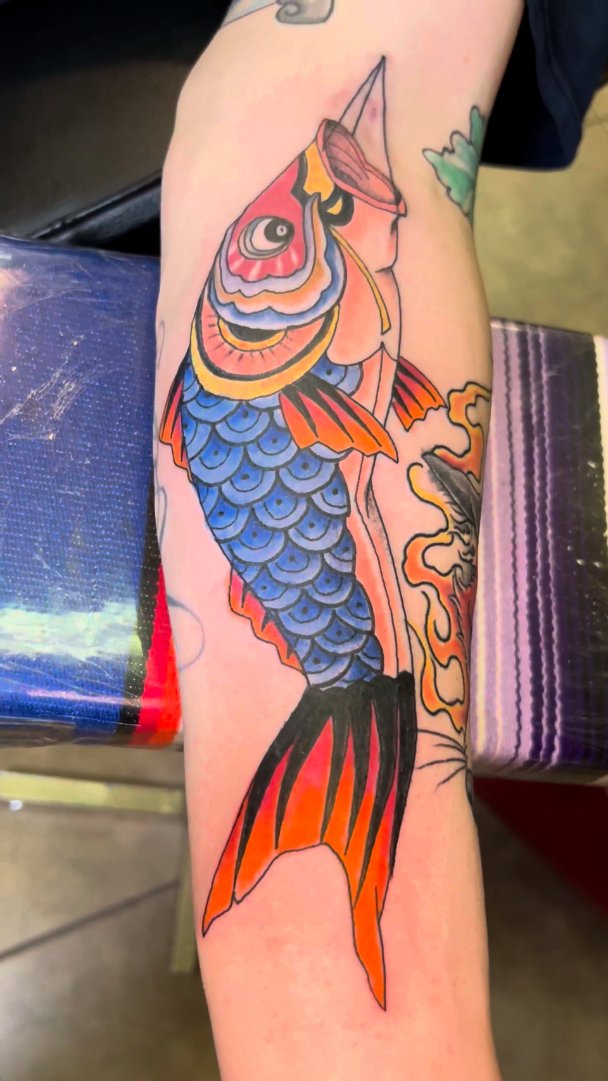 Color koi fish tattoo on a forearm.